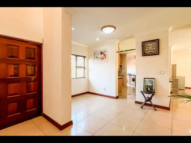 Welcoming entrance hall featuring tiled flooring, a solid wood front door, and a bright, open-plan layout leading into the main living areas.