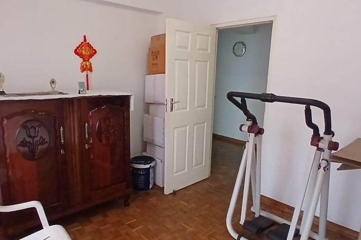 A bedroom featuring parquet flooring and a standard internal door, providing a functional space with potential for modernization.
