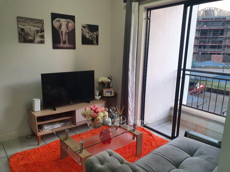 A comfortable living room featuring tiled flooring and a large sliding glass door providing direct access to an outdoor balcony area.