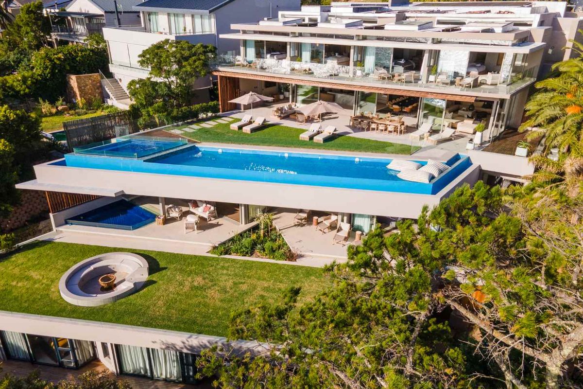 Aerial view of a luxury multi-level residence featuring a tiered garden, infinity swimming pool, expansive balconies, and modern architectural design.