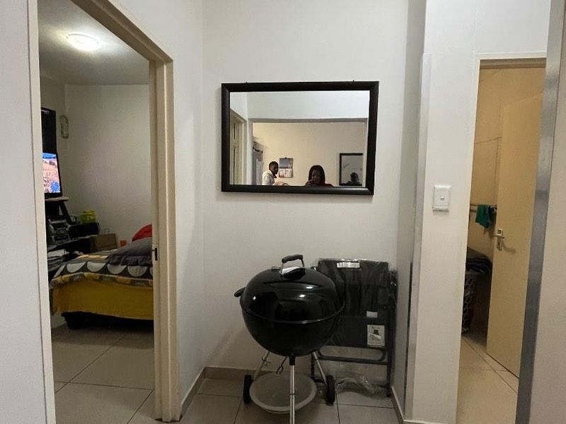 A functional hallway area featuring neutral tiled flooring, providing access to adjacent rooms within the apartment.