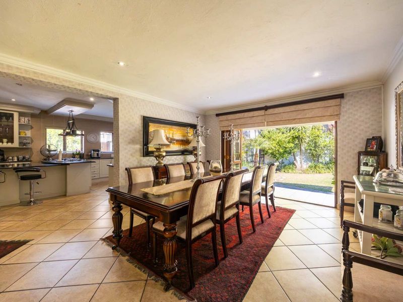 Spacious open-plan dining area featuring tiled floors, recessed lighting, and seamless access to the rear garden through large sliding glass doors.