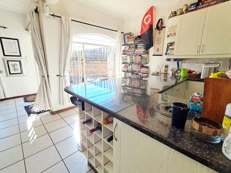 Kitchen featuring granite countertops, a built-in wine rack, and ceramic floor tiles, with direct access to an outdoor patio area.