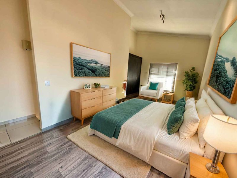 A well-maintained bedroom featuring laminate flooring, a built-in wardrobe, and a tiled entryway, offering a comfortable and functional living space.