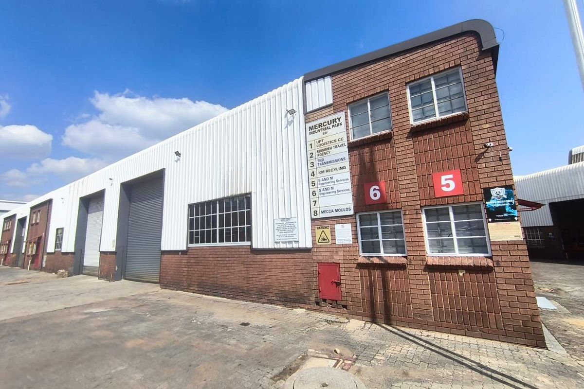 Exterior view of an industrial warehouse unit in Mercury Industrial Park, featuring brick and metal cladding, roller shutter doors, and clear unit signage.