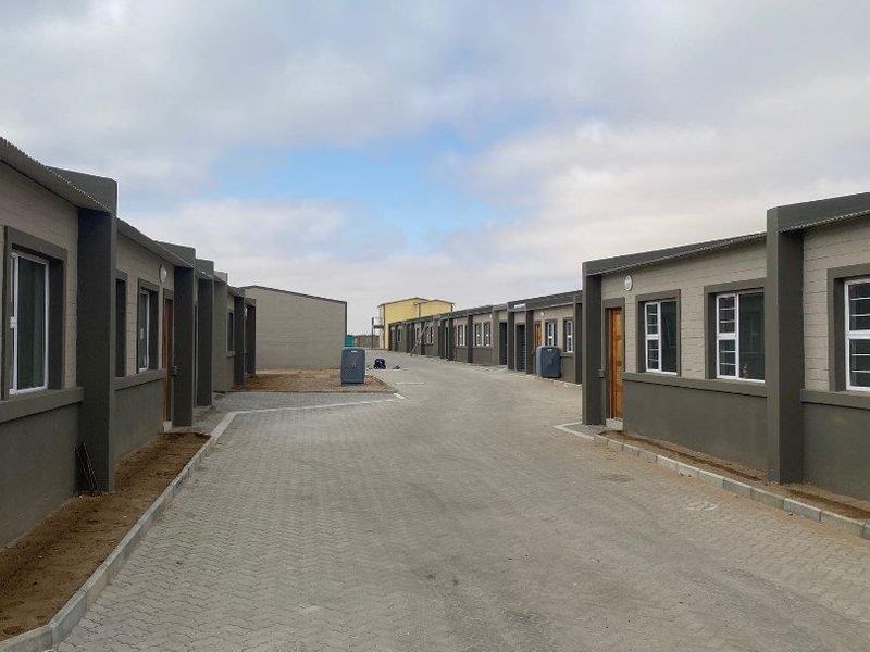 A view of a residential townhouse complex featuring paved driveways and modern exterior finishes on the building facades.