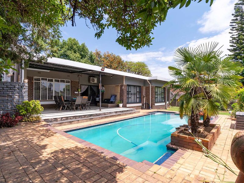 A well-maintained outdoor area featuring a swimming pool, paved surround, and a covered patio space ideal for outdoor entertaining.