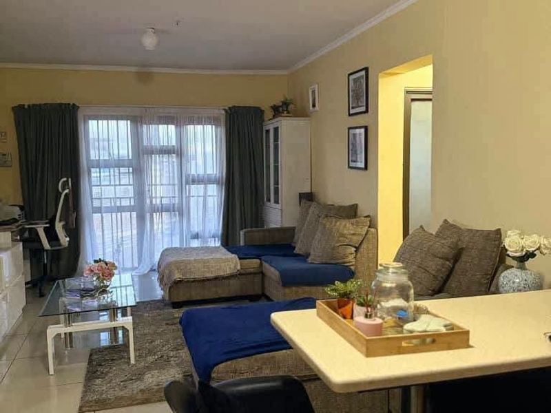 Open plan living and dining area featuring tiled flooring and a large sliding glass door providing access to the balcony.