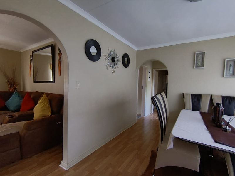 Open plan living and dining area featuring arched architectural transitions and laminate flooring throughout.