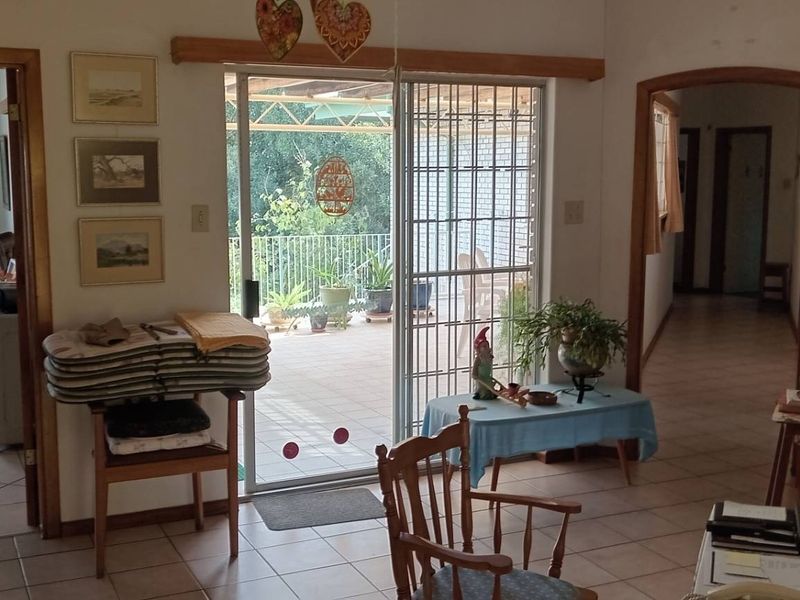 A living area featuring tiled flooring, wooden door frames, and a sliding glass door leading to an outdoor patio space.
