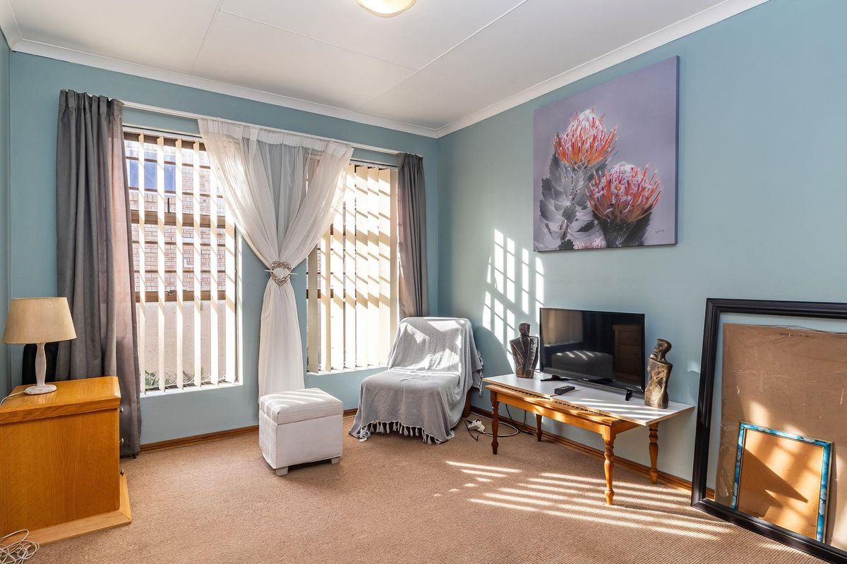 A bedroom featuring carpeted flooring, vertical blinds, and coved ceilings, offering a functional space with natural light.