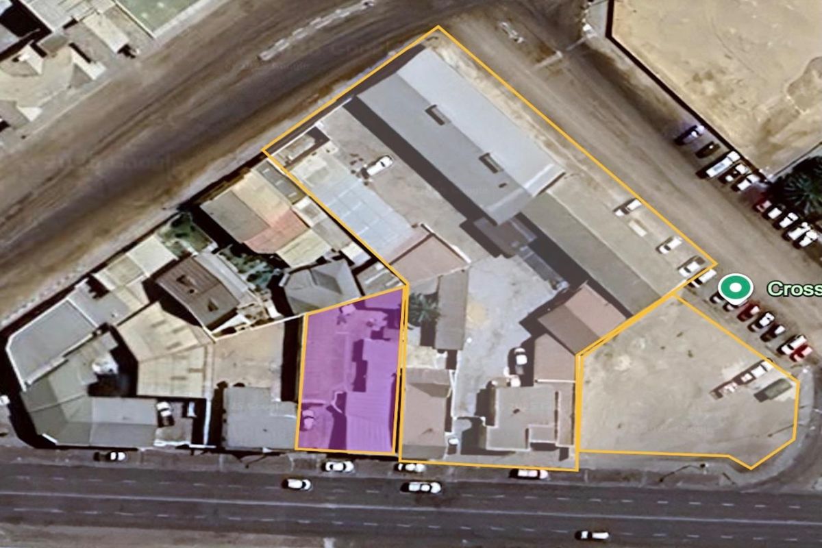 Aerial view of a commercial property site featuring multiple building structures, paved yard areas, and street-front access.