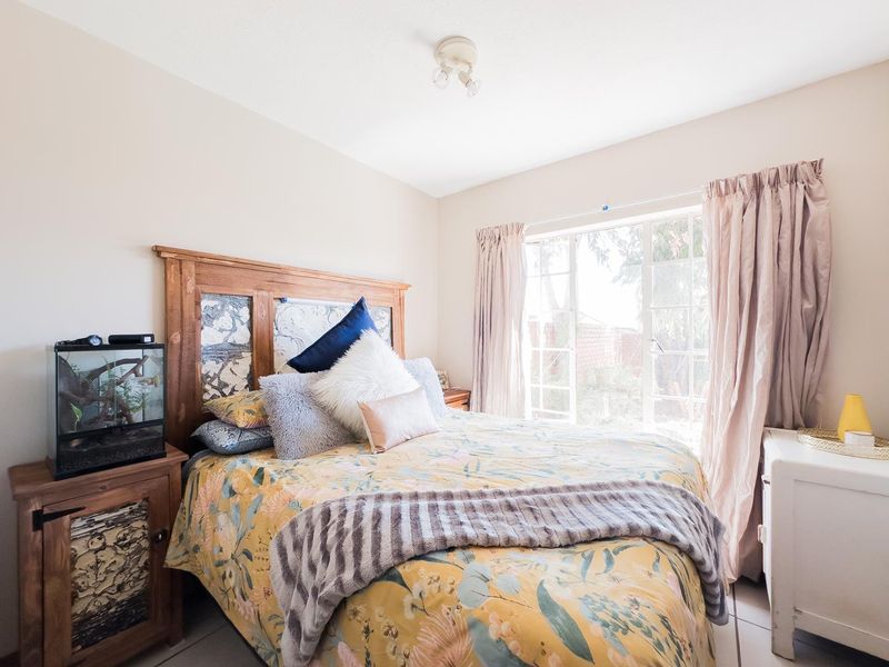 A bedroom featuring tiled flooring and french doors that provide natural light and access to the exterior.