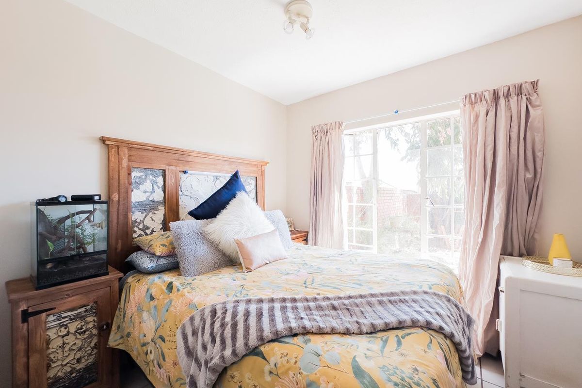 A bedroom featuring tiled flooring and french doors that provide natural light and access to the exterior.