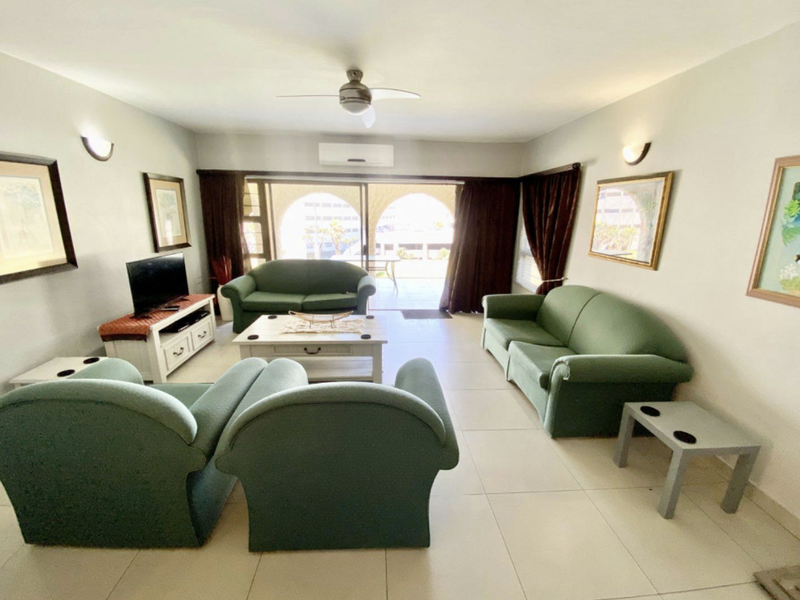 Spacious living room featuring tiled flooring, a ceiling fan, and split-system air conditioning, with direct access to an outdoor patio area.