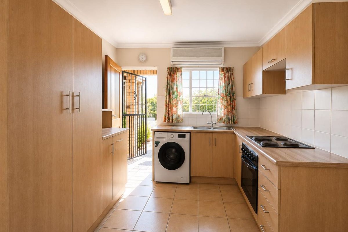 Functional kitchen featuring light wood cabinetry, laminate countertops, integrated electric hob and oven, tiled flooring, and direct access to the exterior.