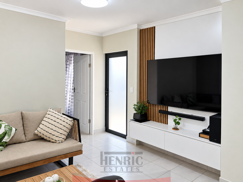 Modern living room featuring a sleek built-in media console with timber slat wall detailing, tiled flooring, and a frosted glass exterior door.