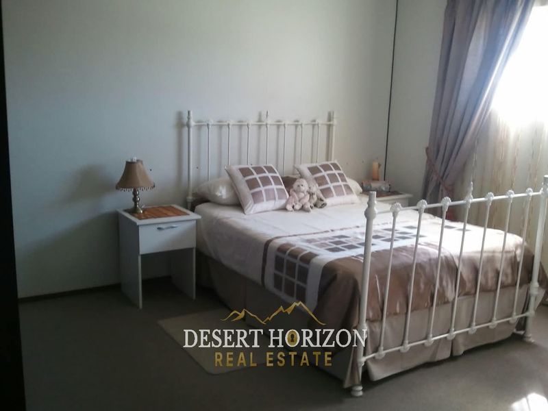 A standard bedroom featuring neutral wall finishes and carpeted flooring, providing a functional space for rest.