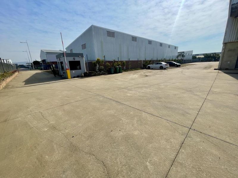 Spacious industrial yard featuring a concrete surface, perimeter fencing, and a dedicated security guard house at the entrance.