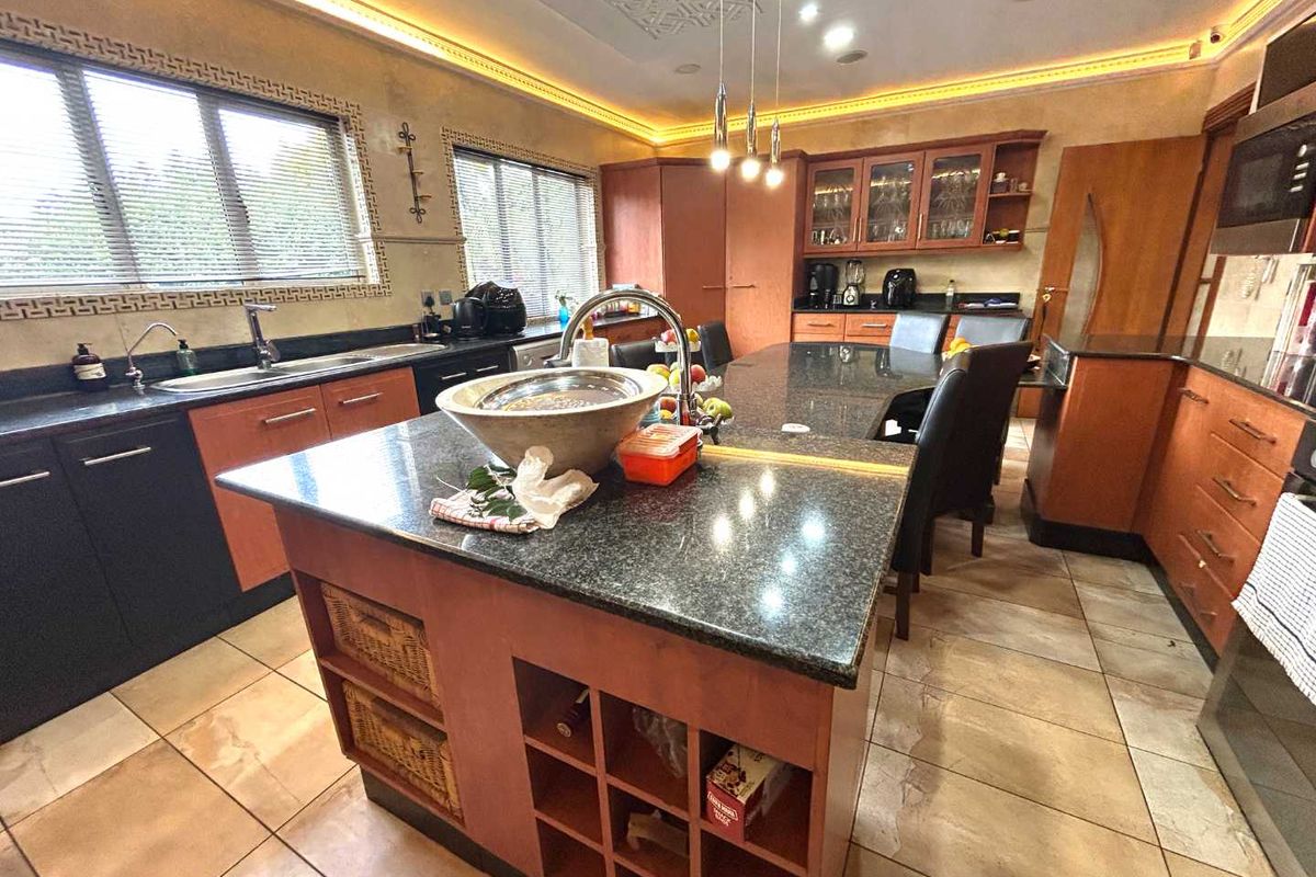 Spacious kitchen featuring a large central island with granite countertops, integrated cabinetry, and recessed ceiling lighting.