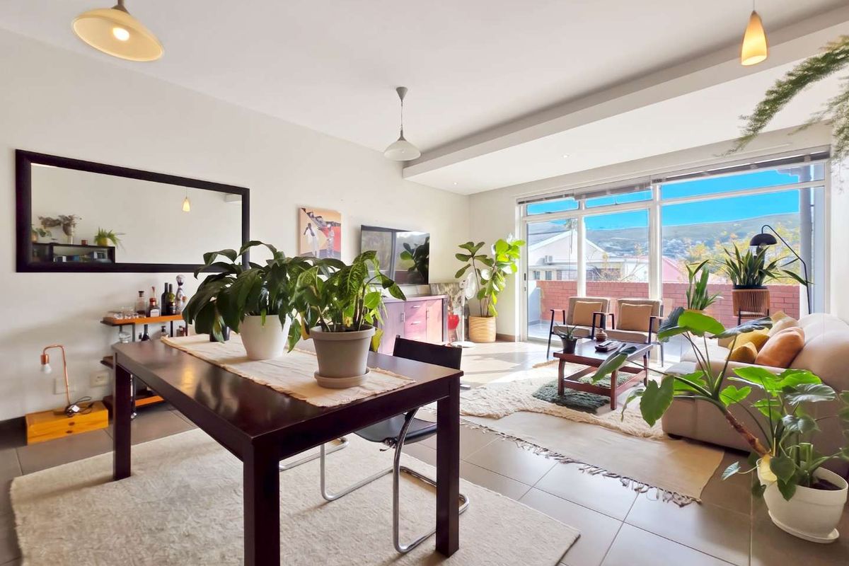 Spacious open-plan living and dining area featuring large sliding glass doors that provide abundant natural light and access to an outdoor balcony.