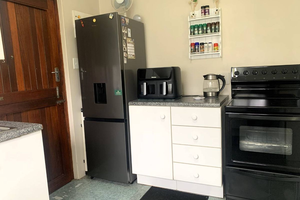 A functional kitchen area featuring white cabinetry, granite-look countertops, and a built-in oven, providing a practical workspace for daily meal preparation.