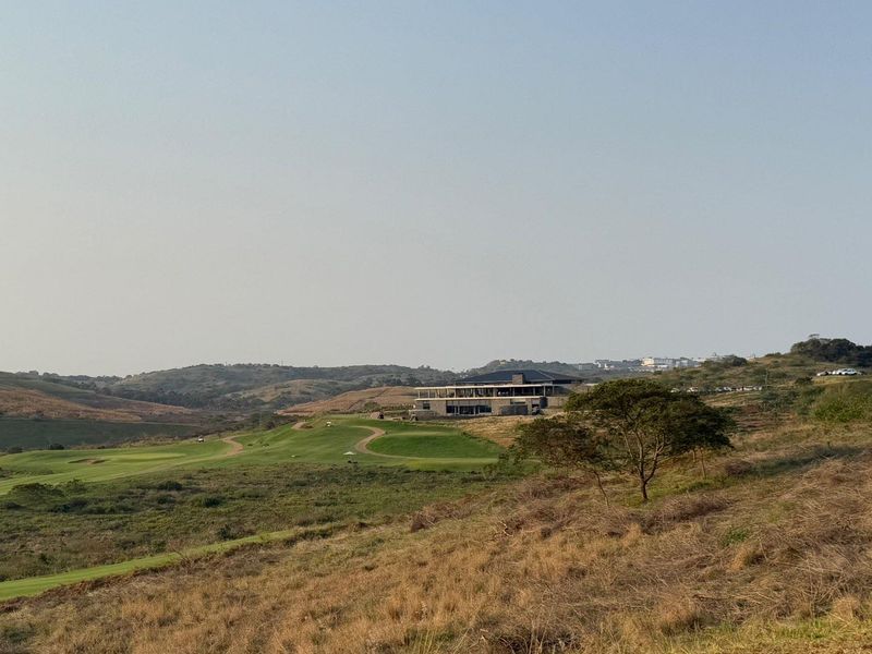 A scenic landscape view overlooking a golf course and rolling hills, showcasing the natural surroundings of the residential land.