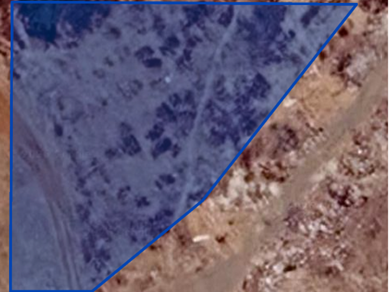 An aerial view of a vacant residential plot of land, highlighting the property boundaries.
