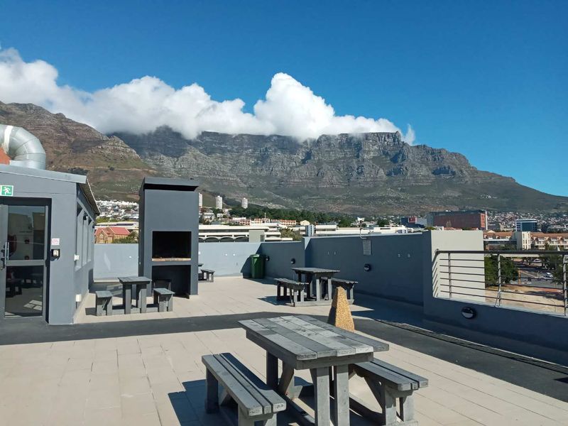 Spacious rooftop terrace featuring a built-in braai area and panoramic mountain views, providing an ideal outdoor entertainment space.
