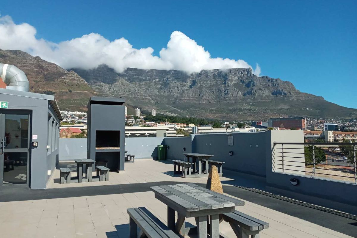 Spacious rooftop terrace featuring a built-in braai area and panoramic mountain views, providing an ideal outdoor entertainment space.