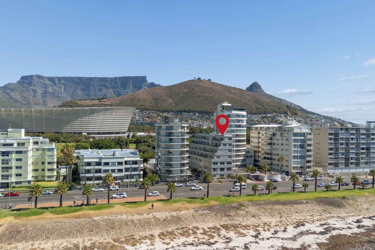 Aerial view of the apartment building complex situated in a prime coastal location with mountain views.