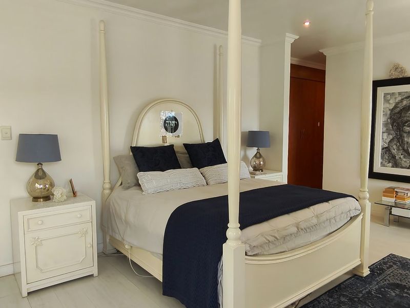 Spacious bedroom featuring built-in cupboards, crown molding, and shutter blinds, offering a bright and well-maintained living space.