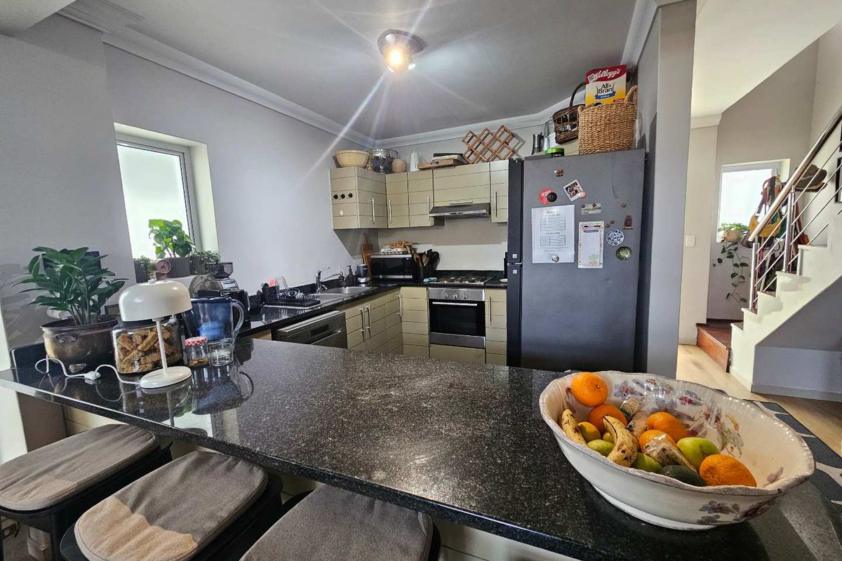 A functional kitchen featuring granite countertops, a breakfast bar, and built-in appliances, offering a practical layout for daily cooking and casual dining.