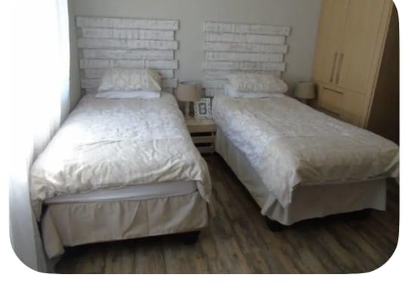 A ground floor bedroom featuring laminate flooring and a built-in wardrobe.