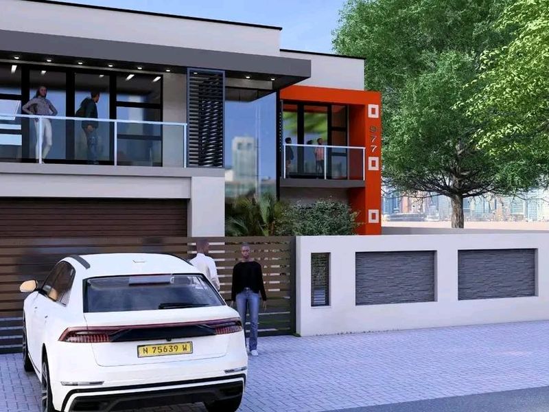 Modern two-story residential facade featuring glass balconies, clean architectural lines, and a secure gated entrance with a private driveway.