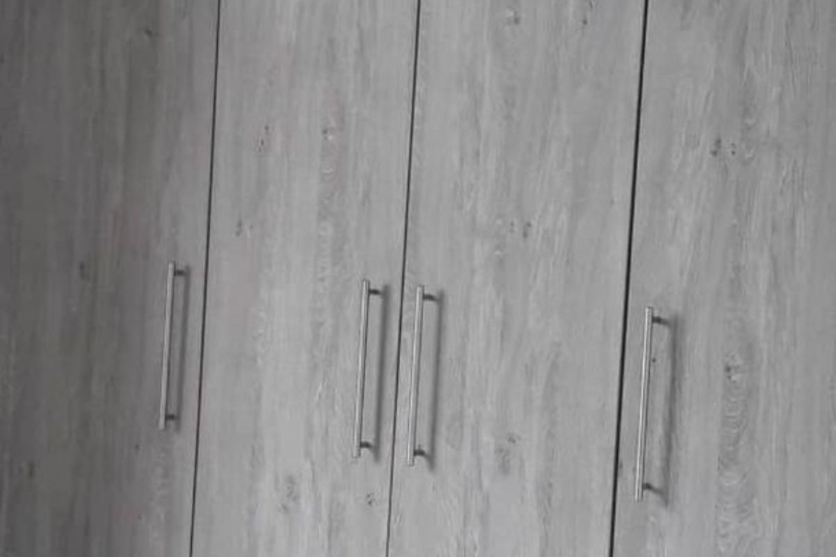 Built-in bedroom cupboards featuring a modern grey wood-grain finish and sleek metal handles.