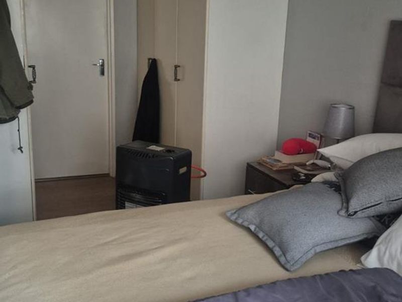 A bedroom featuring built-in cupboards and a ceiling fan, providing functional storage and climate control.