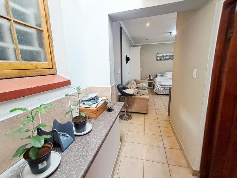 An open-plan living and sleeping area featuring tiled flooring, recessed lighting, and a built-in stone countertop surface.
