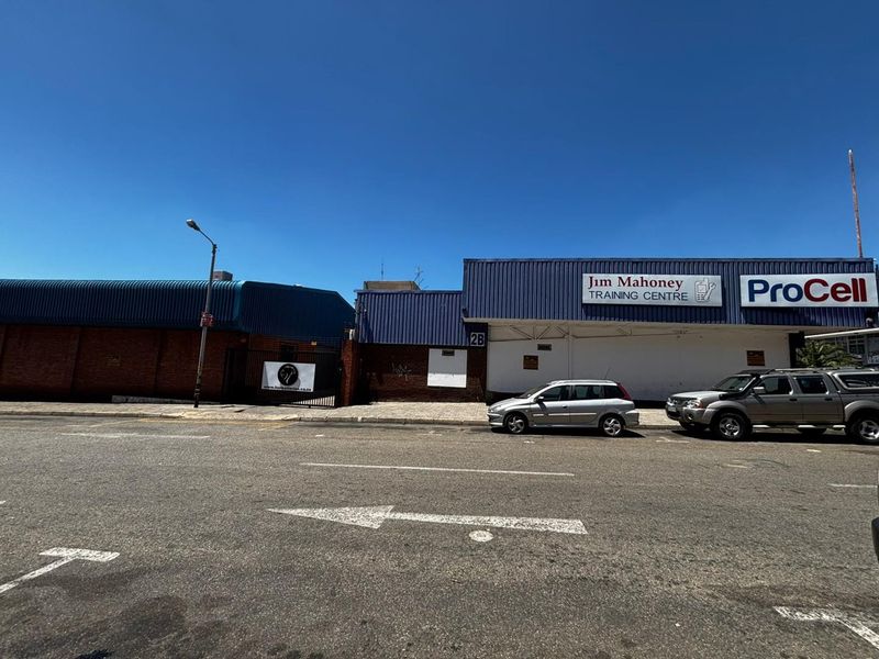 Street-level view of a commercial property featuring a brick and corrugated metal facade with signage for the Jim Mahoney Training Centre and ProCell.