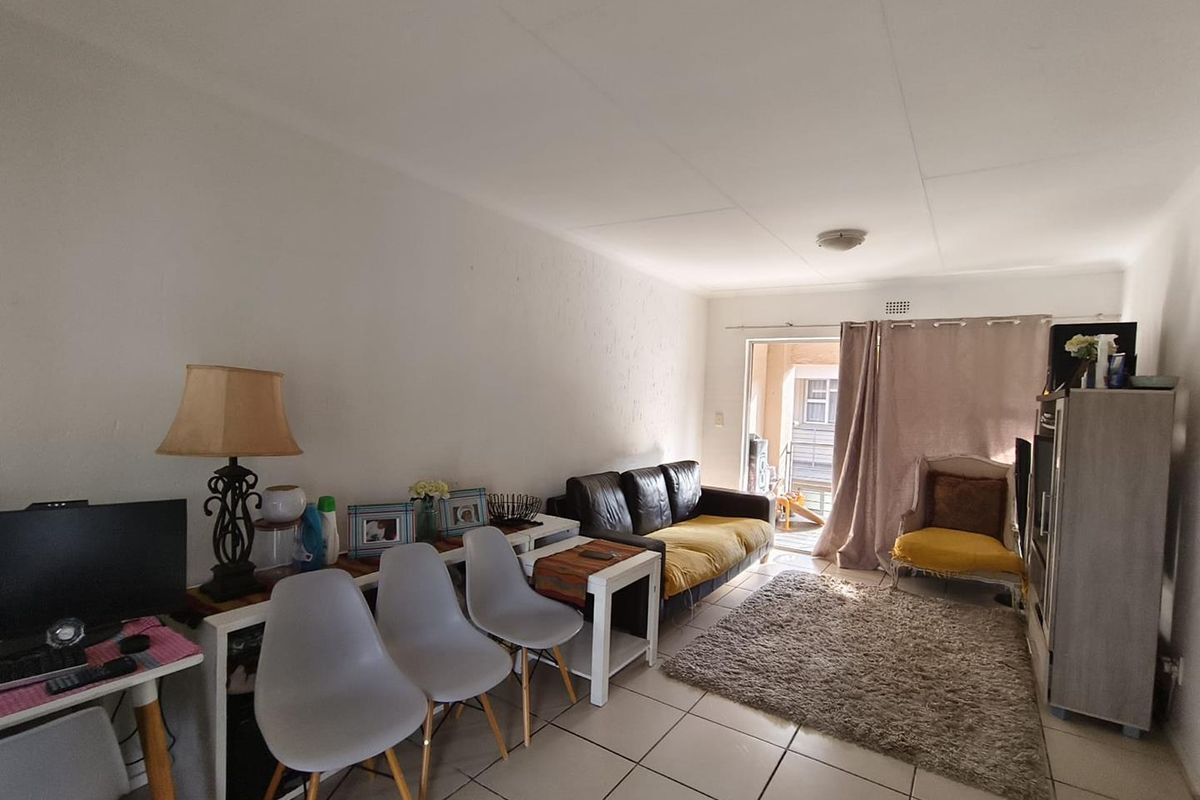 A living room area featuring tiled flooring and a sliding glass door providing access to an outdoor space.