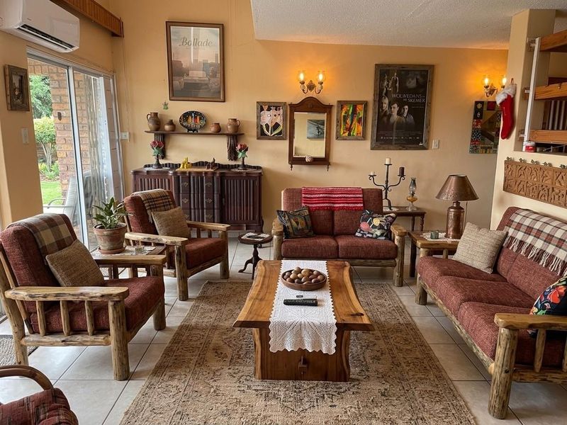 A comfortable living room featuring tiled flooring, wall-mounted air conditioning, and large sliding glass doors providing access to the outdoor area.