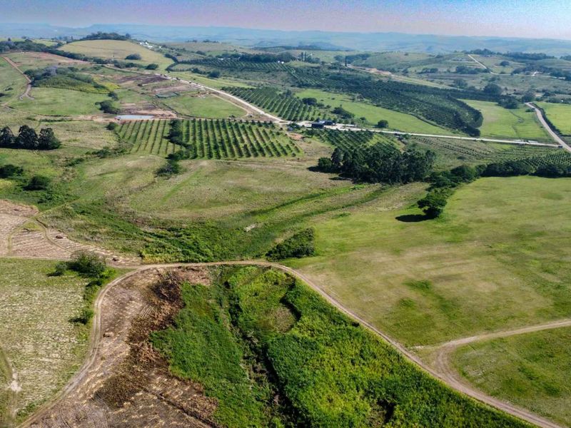 An expansive aerial view of the farm property, showcasing large tracts of agricultural land, orchards, and internal access roads across the rolling landscape.