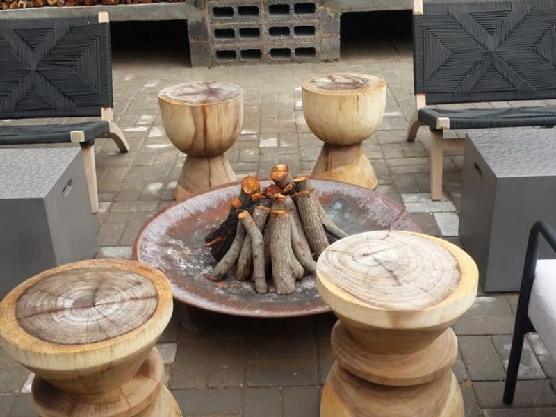 Outdoor patio area featuring paved flooring and a rustic cinder block wall structure, suitable for entertainment.