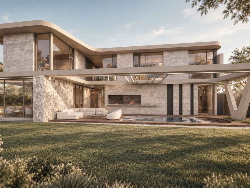 Modern luxury residence featuring a swimming pool, timber decking, stone facade, and a covered patio with a built-in fireplace overlooking the garden.