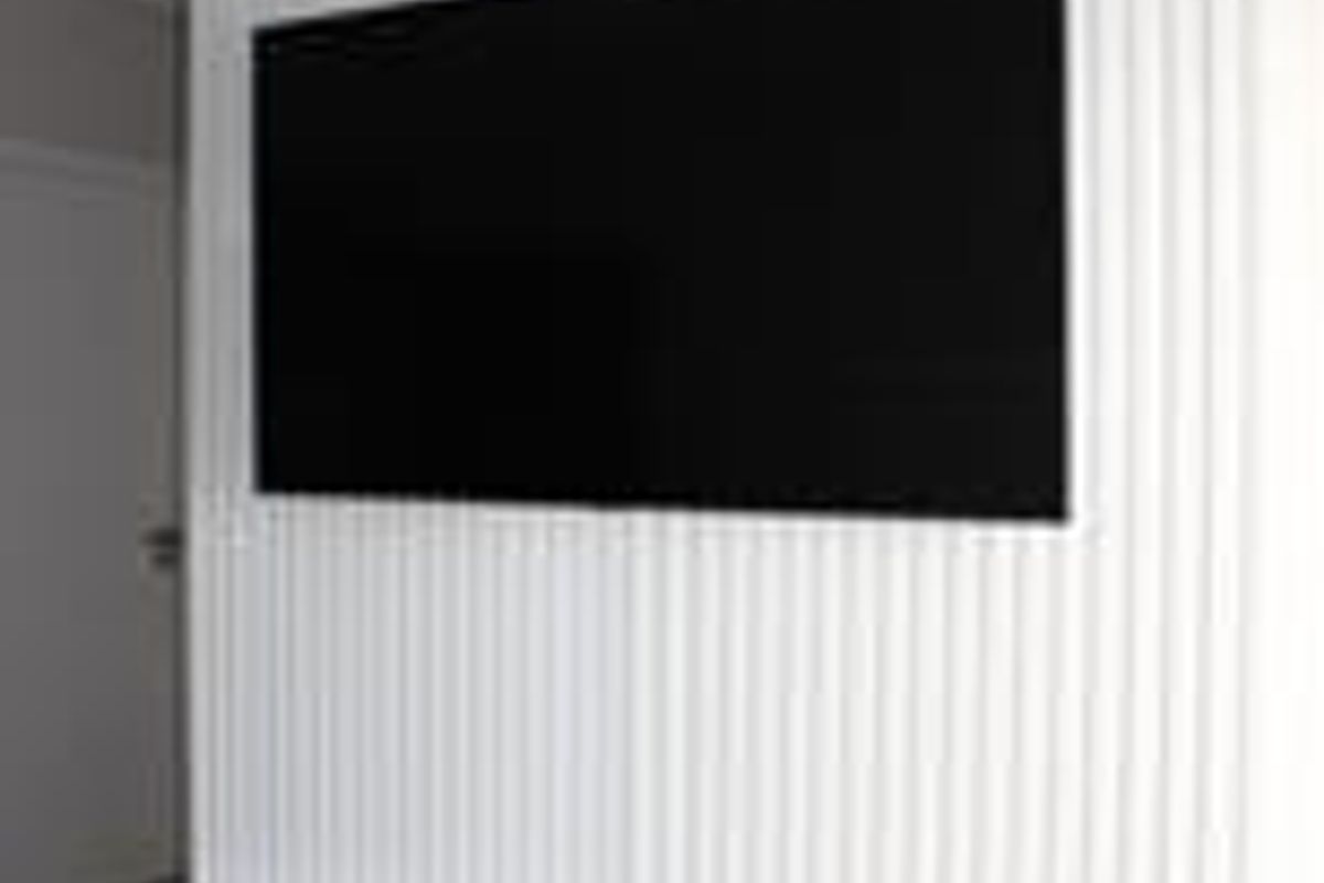 A modern living room feature wall showcasing vertical slatted paneling and a sleek, white built-in floating cabinet.