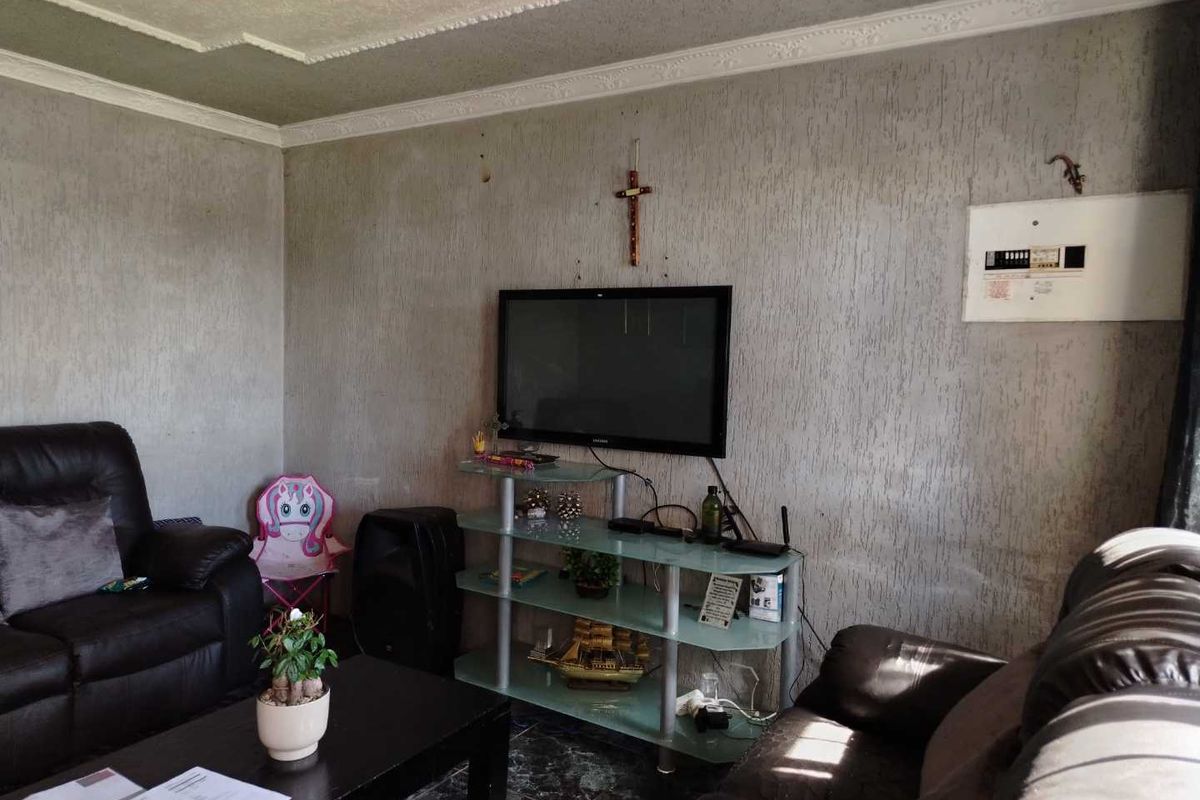 A living room featuring textured wall finishes, crown molding, and a wall-mounted electrical distribution board.