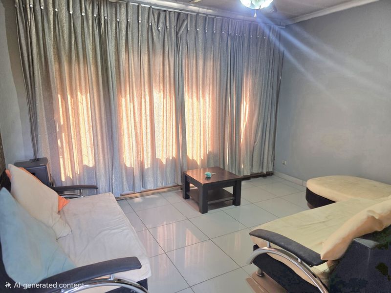 A living room area featuring tiled flooring and a ceiling fan, with large curtains covering the window wall.