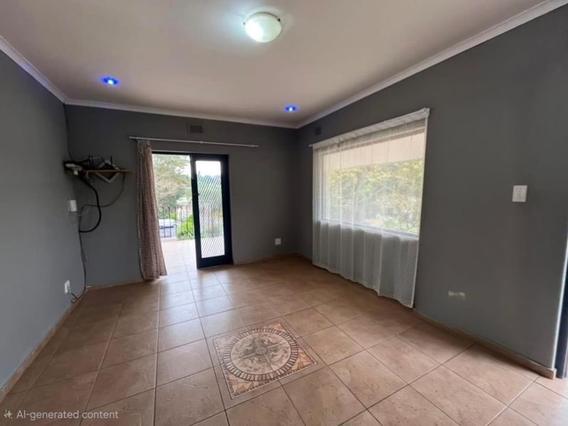 An empty living room featuring tiled flooring with a decorative inlay, recessed lighting, and direct access to an outdoor area through a sliding glass door.