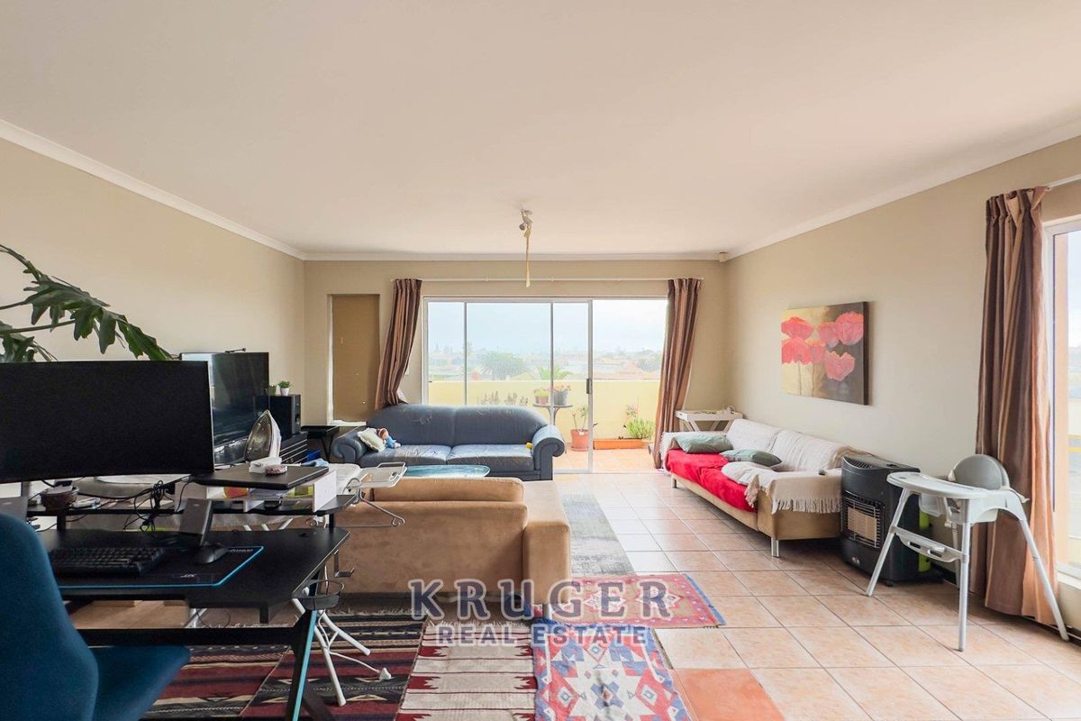 Spacious living area featuring tiled flooring and large sliding glass doors that provide access to an outdoor balcony.