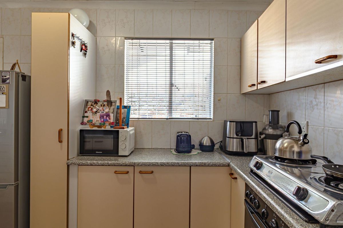 A functional kitchen featuring laminate cabinetry, granite-look countertops, tiled splashbacks, and a built-in gas stove with an integrated oven.